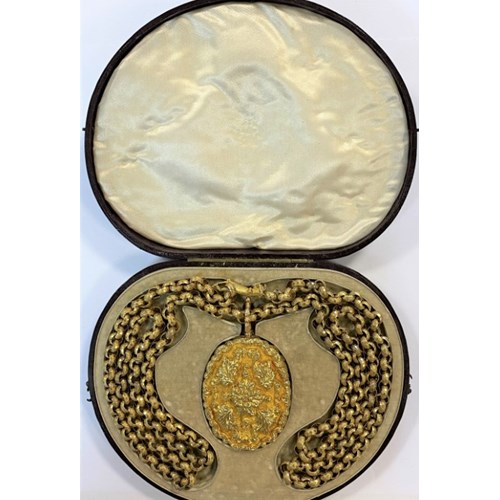 Antique gold double hinged locket on long gold chain, the large carved double hinged oval locket opening on one side to reveal a portrait of a smartly dressed gentleman